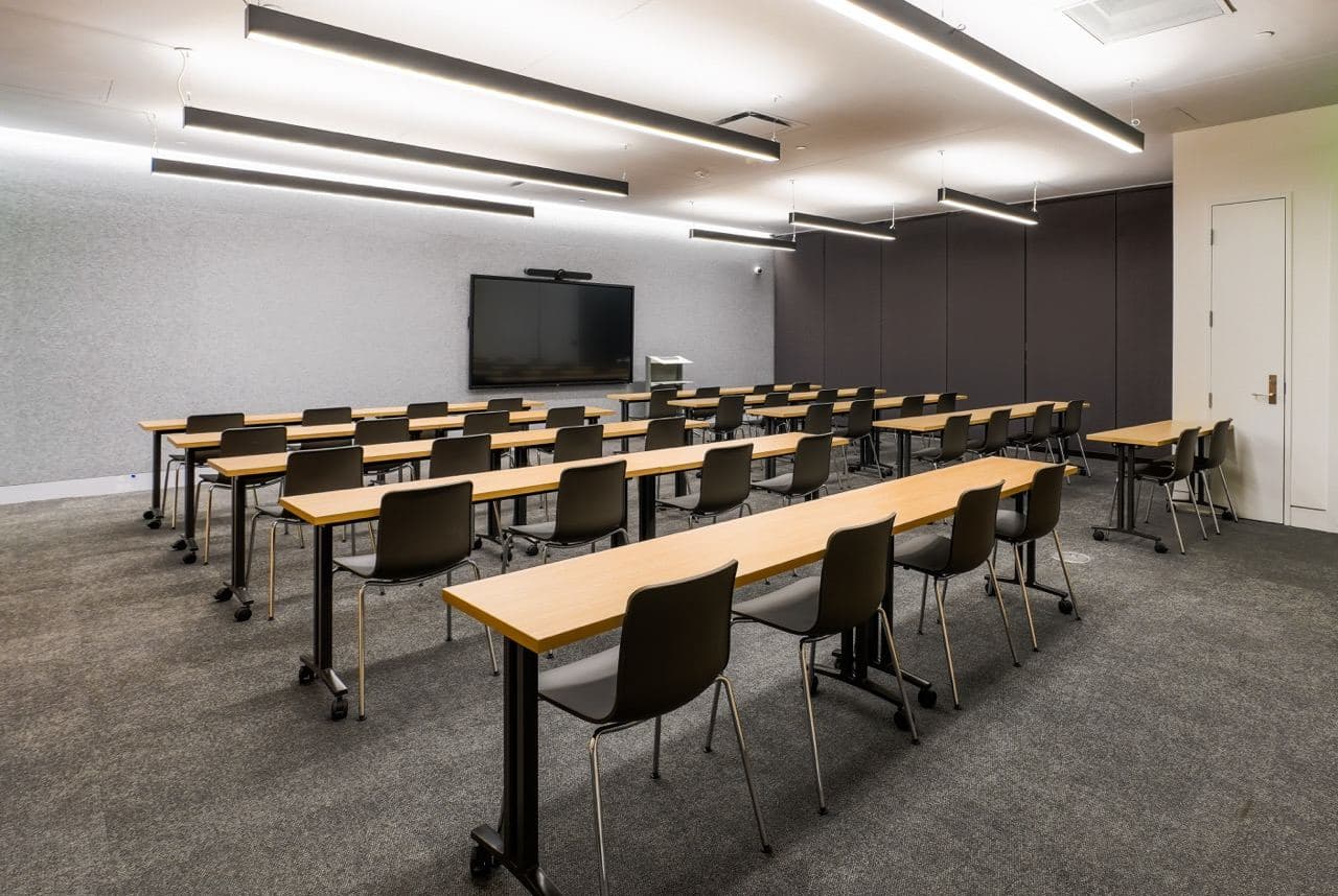A classroom in the Educational Center with rows of tables, chairs and a wall-mounted display