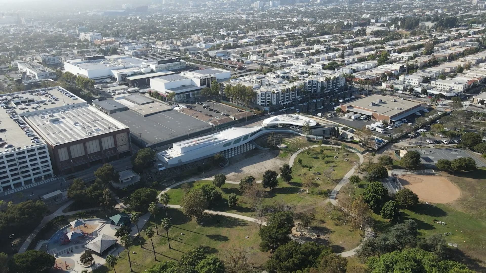 Aerial view of The Goldrich Cultural Center at the edge of Pan Pacific Park, with the Los Angeles basin beyond