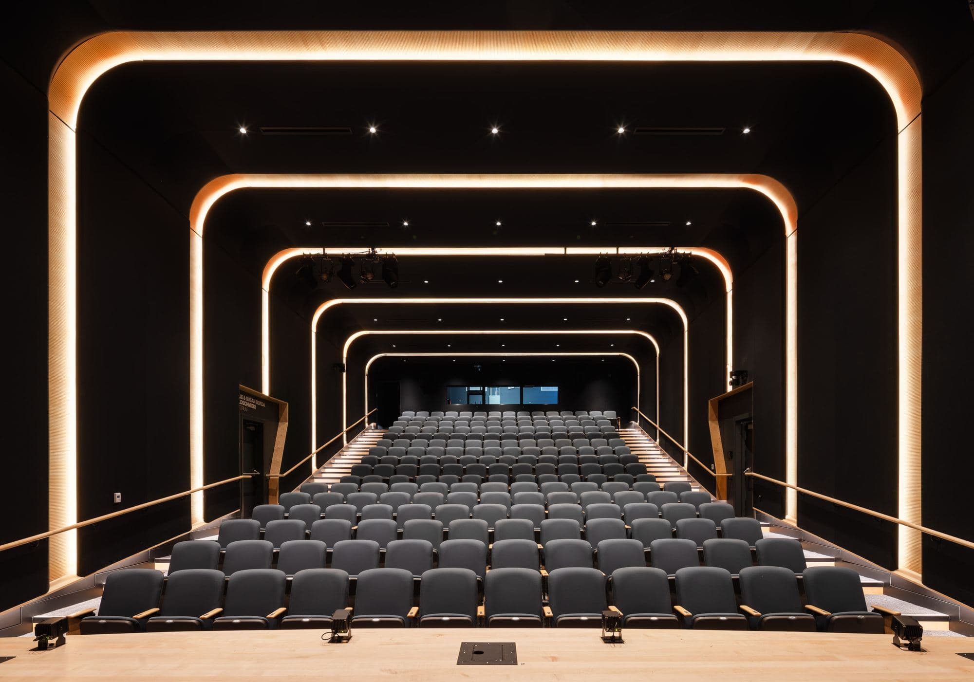 The S. Mark Taper Foundation Theater: raked rows of seats under nested rings of warm light, seen from the stage